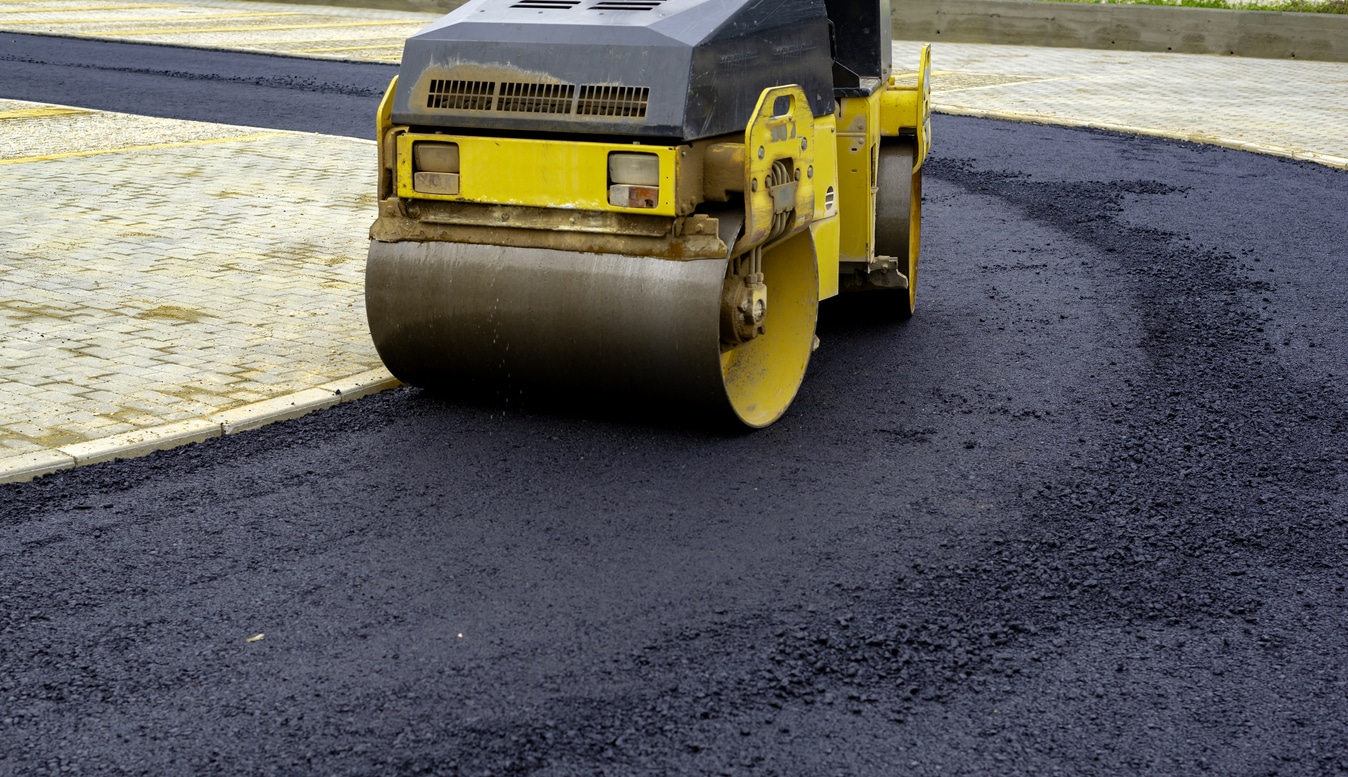 Compact steamroller flatten out the asphalt.